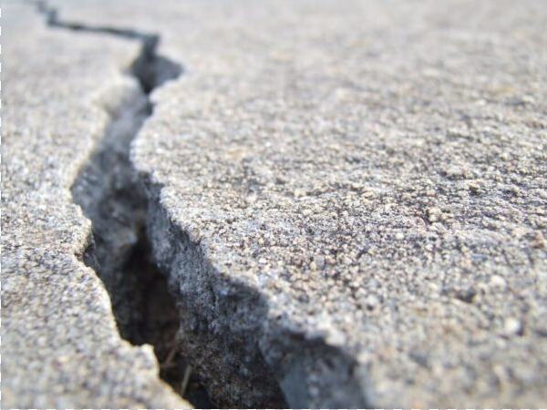 Close-up look at wide crack in concrete sidewalk